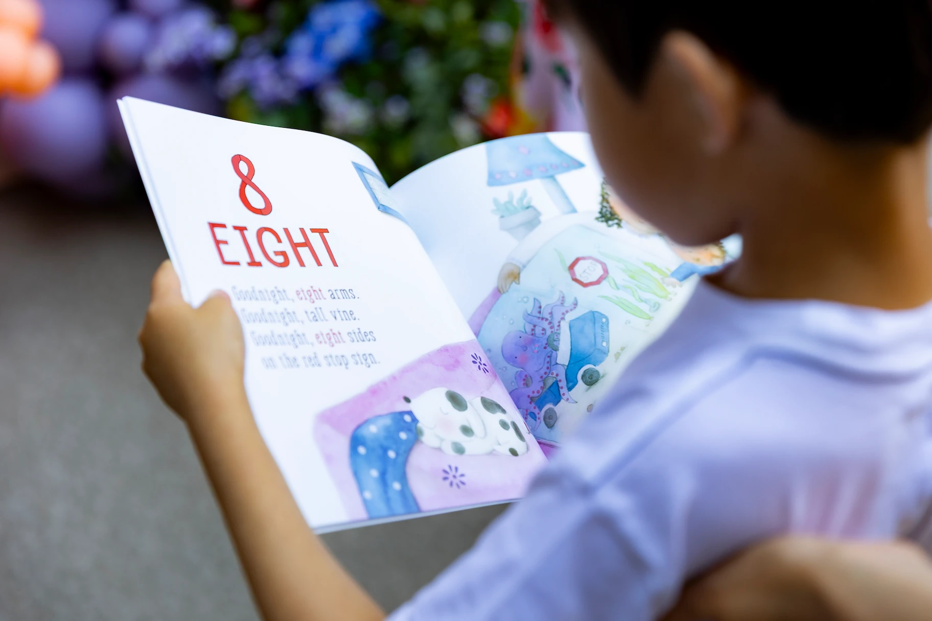 Child in a library reading to himself.