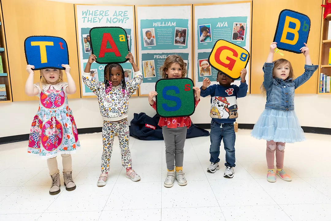 Child in a library reading to himself.